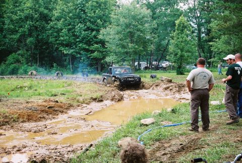 1972 Ford Bronco - A black 1972 Ford Bronco navigates a challenging mud obstacle during an off-road event.