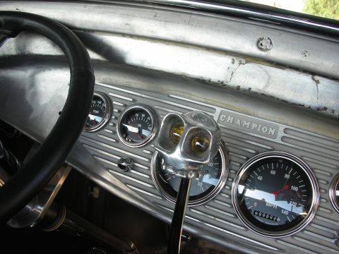 1998 Ford Crown Victoria - Close-up of a custom car's dashboard multiple gauges and a distinctive chrome shifter.
