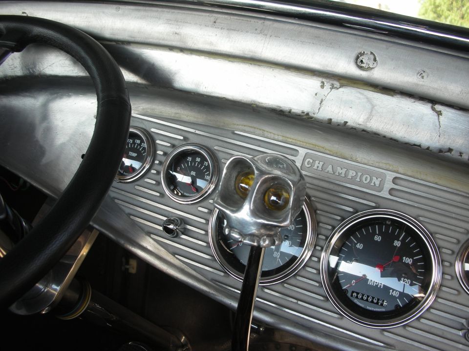Dashboard with steering wheel, gauges, and a unique shifter knob. 'CHAMPION' is visible on the dash