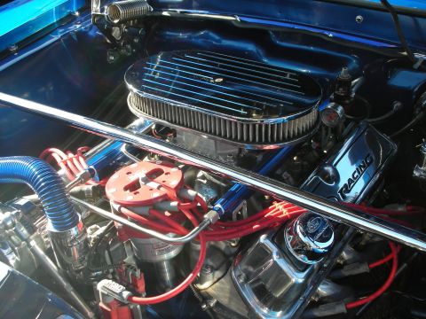 1998 Ford Crown Victoria - Close-up of a modified engine bay with polished components and vibrant blue paint.