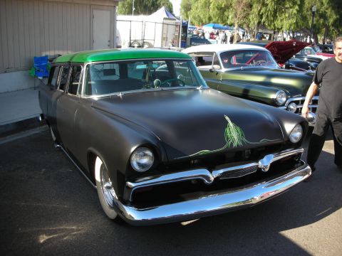 1998 Ford Crown Victoria - A matte black station wagon with a bright green roof and custom green pinstriping is displayed at an outdoor car show.