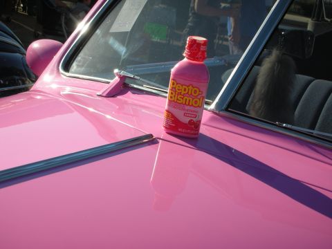 1998 Ford Crown Victoria - A bottle of Pepto-Bismol sits on the hood of a pink car.