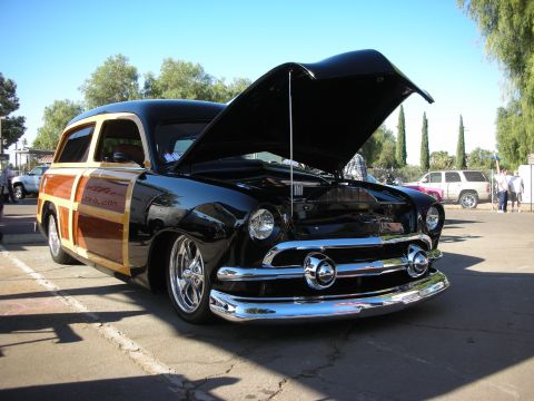 1998 Ford Crown Victoria - A classic black Ford woody wagon is displayed with its hood up, revealing the engine bay.