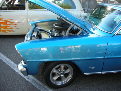 1998 Ford Crown Victoria - Blue classic car with hood open, parked next to a white car with flame decals.