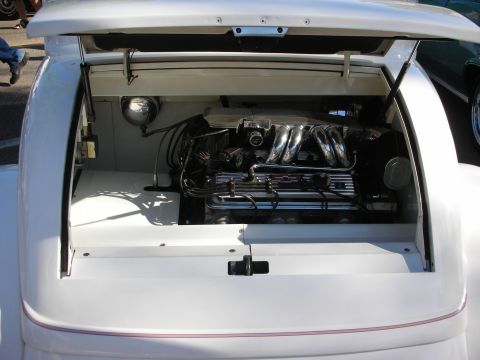1998 Ford Crown Victoria - The engine bay of a white car is open, revealing a V8 engine with polished chrome components.