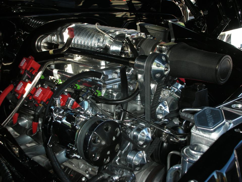 Engine bay with polished chrome supercharger, red MSD ignition coils, and black air intake