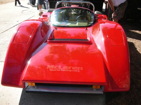 1998 Ford Crown Victoria - A red McLaren sports racing car is viewed from the rear, displaying its branding on the engine cover.