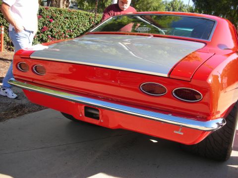 1998 Ford Crown Victoria - Rear view of a classic red car with a silver stripe and chrome accents.
