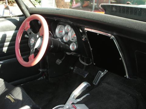 1998 Ford Crown Victoria - The interior of a modified car features a pink steering wheel and a dashboard filled with aftermarket gauges.
