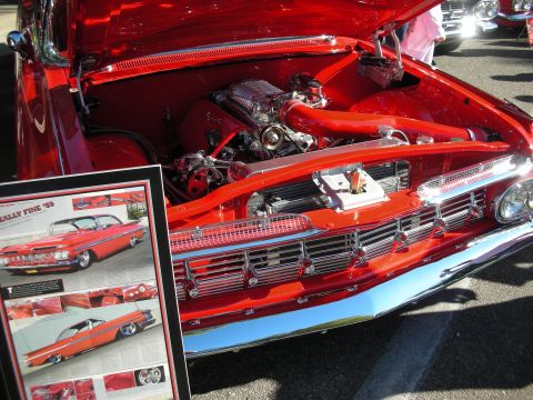 1998 Ford Crown Victoria - Close-up of a red 1959 Chevrolet Impala's engine bay and front grille, with a display board to the left.