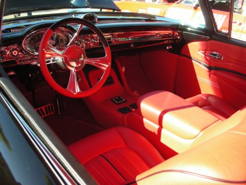 1998 Ford Crown Victoria - The interior of a classic car features bright red upholstery and a custom steering wheel.