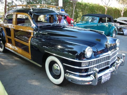 1998 Ford Crown Victoria - A classic woodie wagon with a prominent chrome grille and wood paneling is parked outdoors.