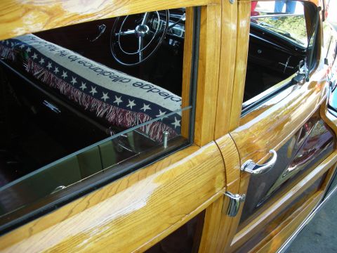 1998 Ford Crown Victoria - Interior view of a classic woodie wagon, showing the steering wheel and a patriotic blanket on the seat.