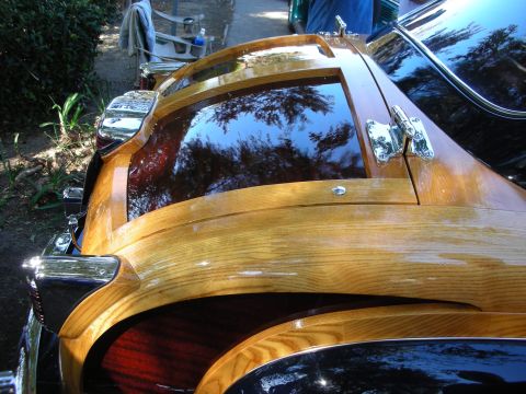 1998 Ford Crown Victoria - A woodie wagon's rear window is visible, with chrome accents and wooden paneling.
