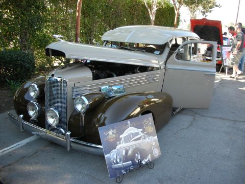 1998 Ford Crown Victoria - A vintage Cadillac is displayed with its hood and door open, accompanied by a promotional card.