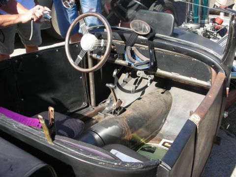 1998 Ford Crown Victoria - The interior of a custom vintage vehicle shows a banjo steering wheel, floor-mounted shifter, and exposed metal components.