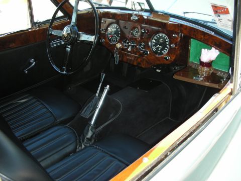 1998 Ford Crown Victoria - The interior of a classic car features wood grain dashboard accents and black leather seats.