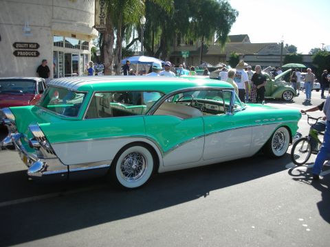 1998 Ford Crown Victoria - A classic two-tone green and white station wagon is parked on the street at a car show, with other vehicles and people in the background.
