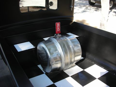 1998 Ford Crown Victoria - A beer keg with a Budweiser tap sits in the bed of a black truck with a checkerboard floor.