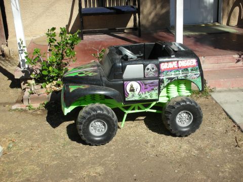 1998 Ford Crown Victoria - This toy monster truck features "Grave Digger" branding and a distinctive green frame.