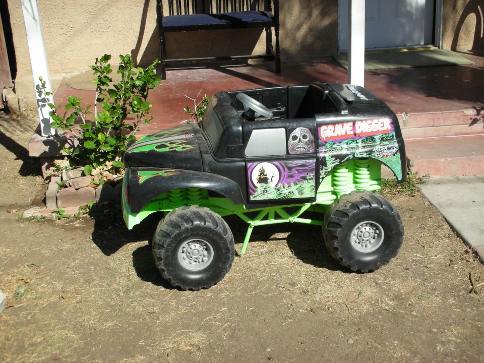 Black toy monster truck with green frame and "Grave Digger" graphics