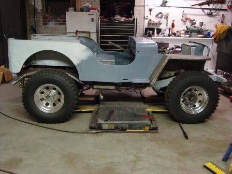 1948 Jeep Wrangler - This Jeep CJ-5 body is in primer and appears to be undergoing restoration work in a workshop.