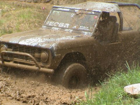 1972 Ford Bronco - Muddy 1972 Ford Bronco navigating a challenging off-road course.