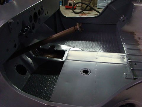 1948 Jeep Wrangler - The interior of a vehicle, possibly a Jeep, is shown during a restoration project with gray primer and diamond plate flooring.