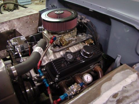 1948 Jeep Wrangler - Close-up view of a V8 engine in an engine bay, custom fuel lines and an air filter.