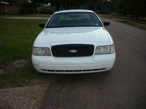 2001 Ford Crown Victoria - A white 2001 Ford Crown Victoria is parked on a residential street, facing the camera.