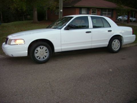2001 Ford Crown Victoria - A white 2001 Ford Crown Victoria sedan is parked on a residential street.