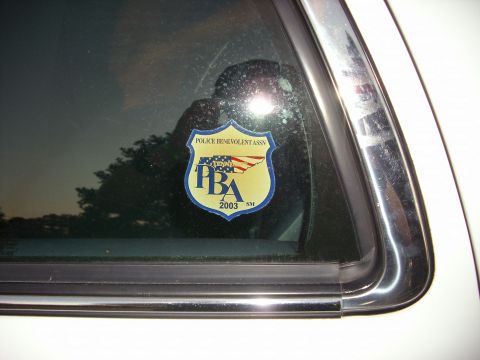 2001 Ford Crown Victoria - Close-up of a PBA sticker on a vehicle's rear window, showing the year 2003.