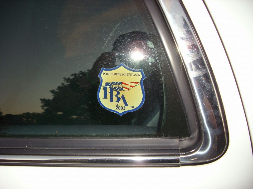 Police Benevolent Assn sticker with '2003' visible on a car window