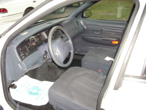 2001 Ford Crown Victoria - The interior of a 2001 Ford Crown Victoria is visible, including the dashboard, steering wheel, and seats.