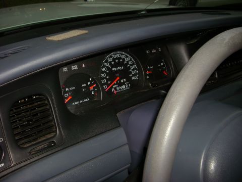 2001 Ford Crown Victoria - Interior view of a 2001 Ford Crown Victoria dashboard with gauges and steering wheel.