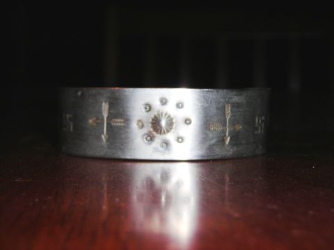 1984 Ford Bronco - A close-up of a decorative metal bracelet with Native American-inspired etchings.