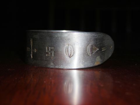 1984 Ford Bronco - A silver ring is shown with various etched symbols, including a swastika, arrows, and geometric designs.
