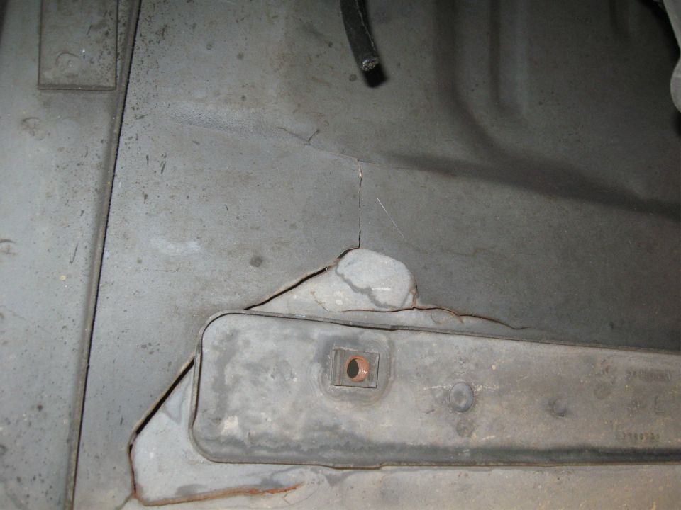 Underbody part with cracks and a metal bracket