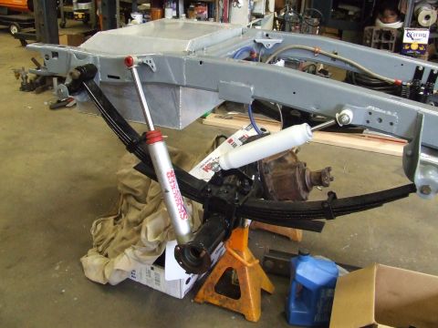 1967 Ford Bronco - Suspension components and frame are laid out in a workshop setting, awaiting assembly.