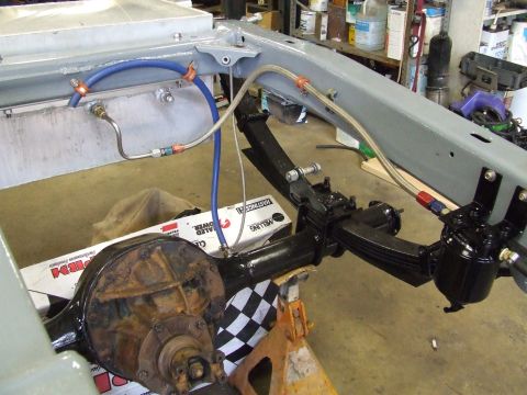 1967 Ford Bronco - Close-up view of vehicle chassis components, including suspension and brake lines, during what appears to be a restoration or repair proces…