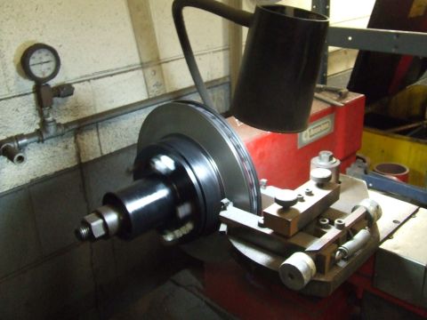 1967 Ford Bronco - A brake rotor is being machined on a lathe, with a pressure gauge visible on the wall.