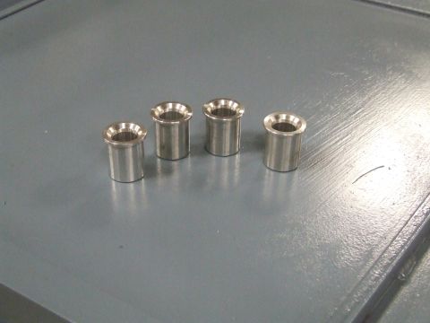 1967 Ford Bronco - Four metal bushings are laid out on a gray surface, with a Supermotors logo in the corner.