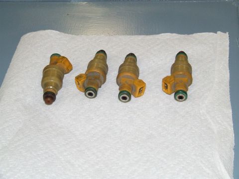 1967 Ford Bronco - Four fuel injectors are laid out on a white paper towel, with a website watermark at the bottom right.