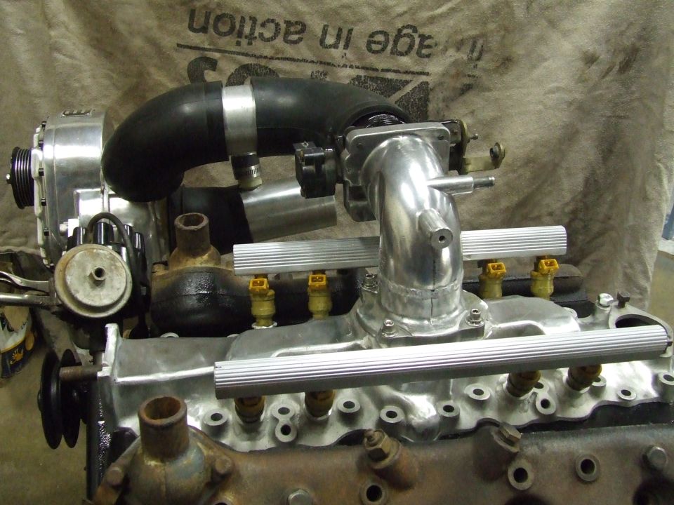 Engine block with supercharger, intake manifold, and fuel rails. Silver and black