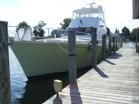 1976 Ford F-150 - A yacht is tied to a wooden dock on a sunny day.