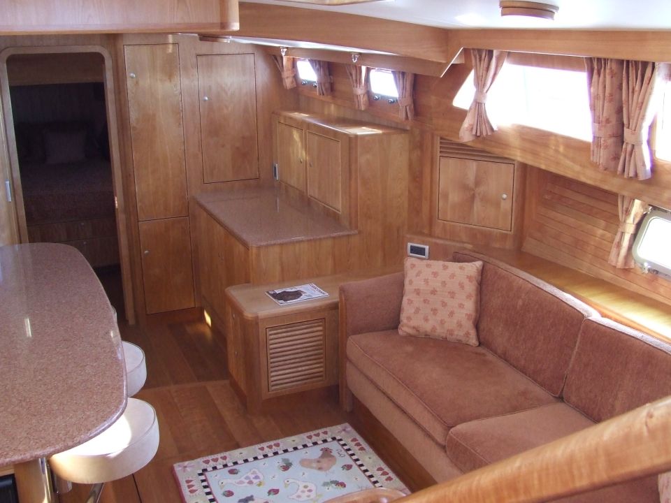 Yacht interior with wood paneling, a brown sofa, and a small table