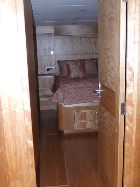 1976 Ford F-150 - The interior of a yacht cabin features a bed with plush pillows and intricate wood paneling throughout the room.