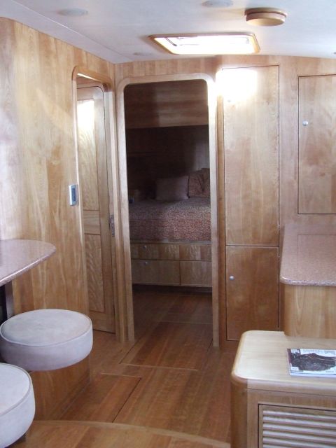 1976 Ford F-150 - The interior of a boat cabin features wood paneling and a sleeping area visible through an open doorway.