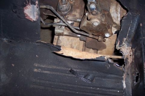 1976 Ford Bronco - Significant rust damage is visible on the floor pan and transmission tunnel, obscuring vehicle identification.