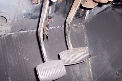 1976 Ford Bronco - Interior view of vehicle floor pedals, showing signs of wear and rust.